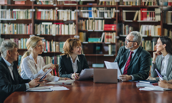 An image of four professors sitting around a table talking